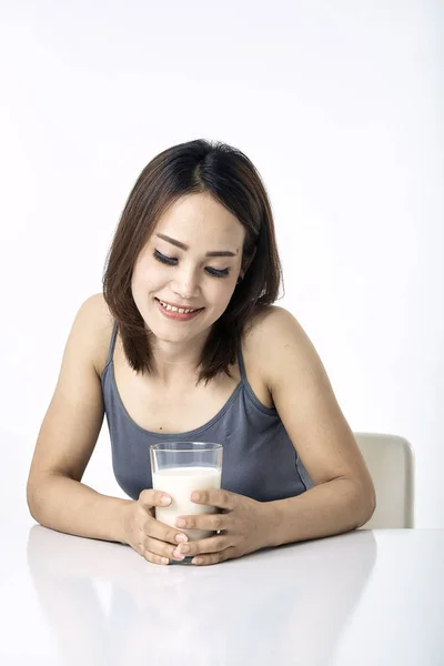 Jonge vrouw drinken melk op tafel — Stockfoto