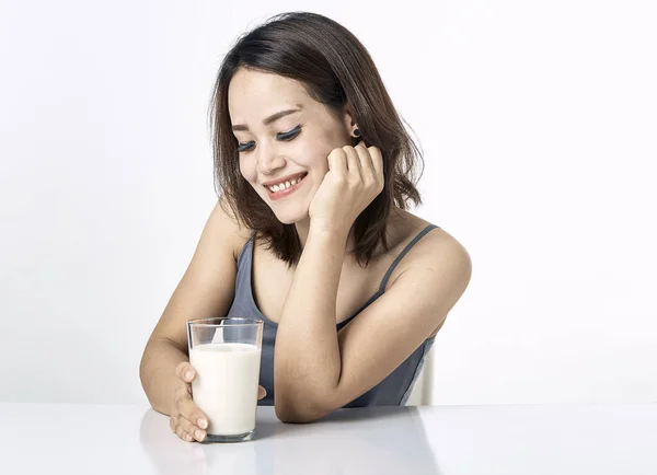 Mladá žena konzumní mléko na stole — Stock fotografie