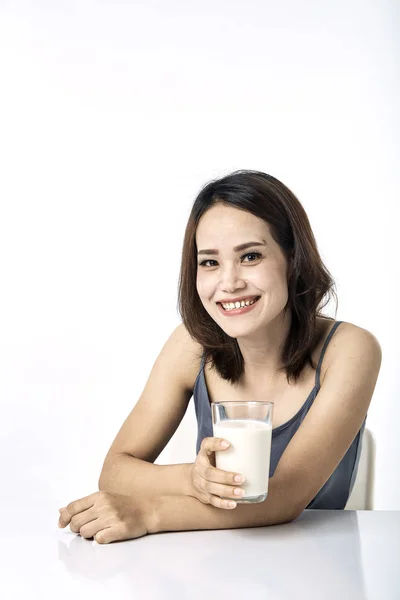 テーブルの上でミルクを飲む若い女性 — ストック写真