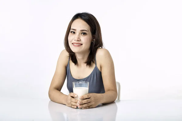 Jovem mulher bebendo leite na mesa — Fotografia de Stock