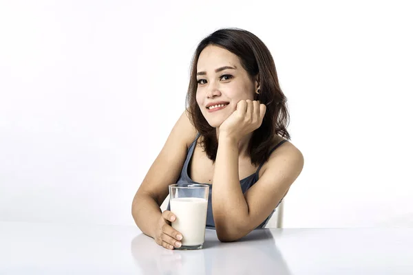 Jonge vrouw drinken melk op tafel — Stockfoto