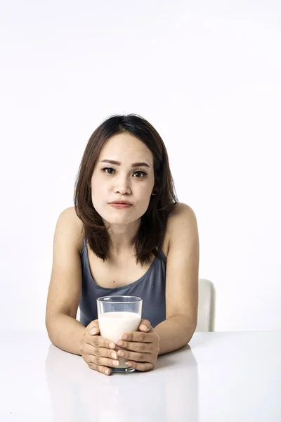 Joven bebiendo leche en la mesa — Foto de Stock