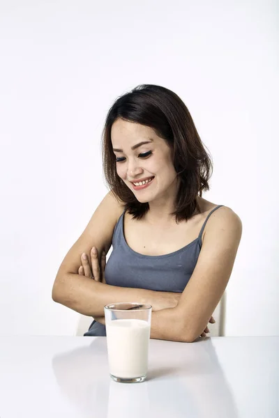 Jonge vrouw drinken melk op tafel — Stockfoto