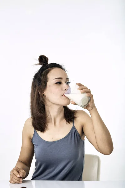 Mladá žena konzumní mléko na stole — Stock fotografie