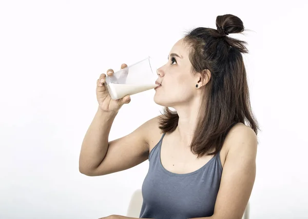 年轻女子在桌子上喝牛奶 — 图库照片