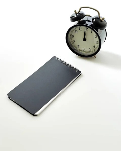 空白の白いノートブックが付いている目覚まし時計 — ストック写真