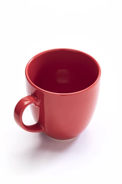 Rote Keramiktasse auf weißem Hintergrund — Stockfoto