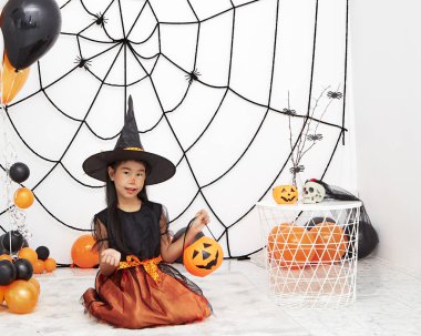 Bir balkabağı ile Mutlu Cadılar Bayramı küçük cadı