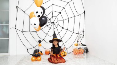 Bir balkabağı ile Mutlu Cadılar Bayramı küçük cadı