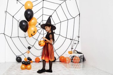 Bir balkabağı ile Mutlu Cadılar Bayramı küçük cadı