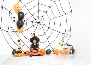 Bir balkabağı ile Mutlu Cadılar Bayramı küçük cadı