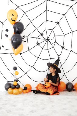 Bir balkabağı ile Mutlu Cadılar Bayramı küçük cadı