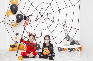 İki Asya sevimli komik kız kardeşi tatil kutlamak. Karnaval kostümleri Neşeli çocuklar Cadılar Bayramı için hazır