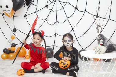 İki Asya sevimli komik kız kardeşi tatil kutlamak. Karnaval kostümleri Neşeli çocuklar Cadılar Bayramı için hazır