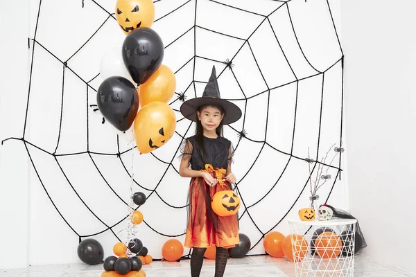 Happy Halloween little witch with a pumpkin