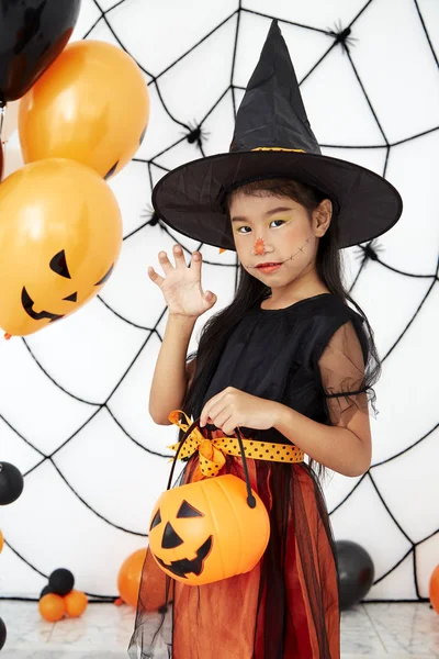 Happy Halloween little witch with a pumpkin