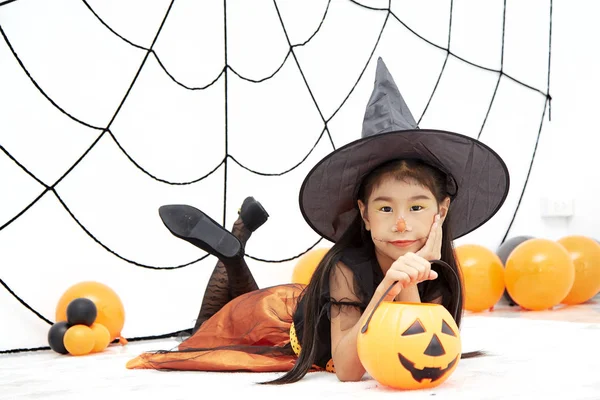Happy Halloween little witch with a pumpkin