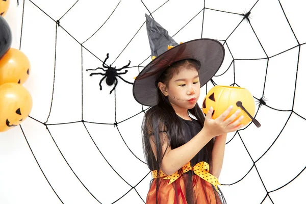 Fröhliche kleine Hexe zu Halloween mit einem Kürbis — Stockfoto