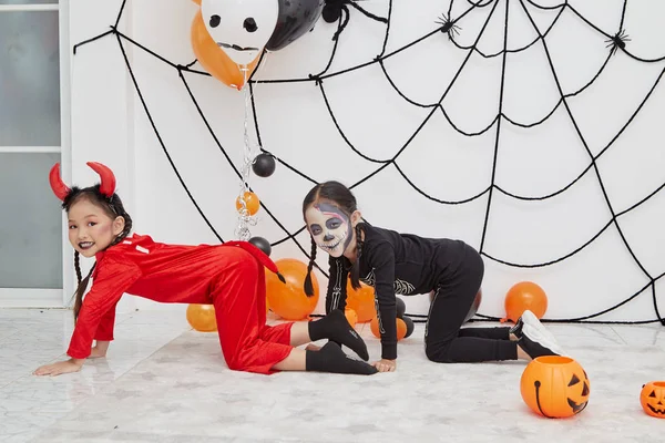 Twee kleine meisjes in kostuums voor Halloween — Stockfoto