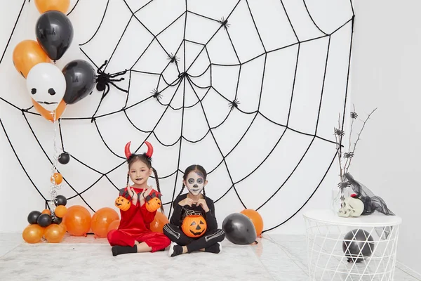 Twee kleine meisjes in kostuums voor Halloween — Stockfoto