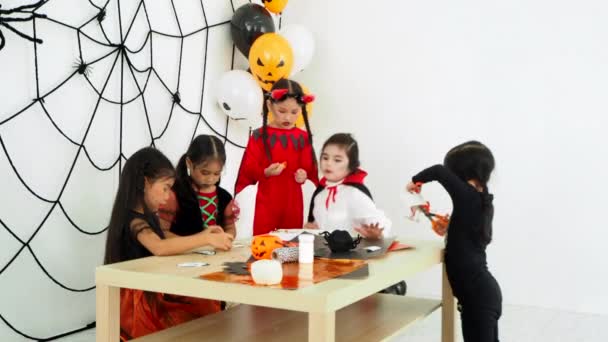 组小亚洲女孩在万圣节服装一起庆祝在万圣节派对在房间的节日 — 图库视频影像