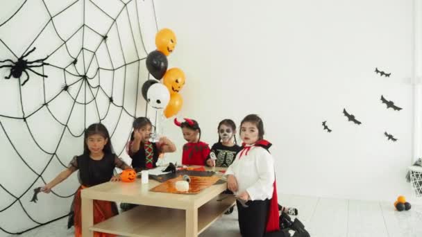 ハロウィーンの衣装でグループ小さなアジアの女の子は部屋でハロウィーンパーティーで一緒に休日を祝います — ストック動画