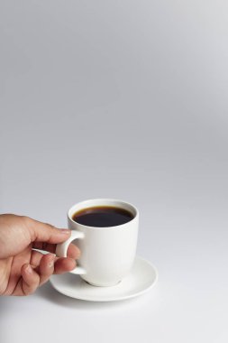 El kahve beyaz bir fincan tutarak