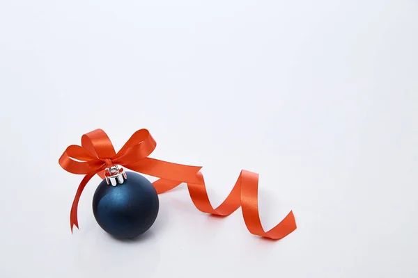 Синій різдвяний м'яч з червоною стрічкою на білому — стокове фото