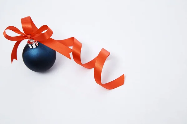Bola de Natal azul com fita vermelha em um branco — Fotografia de Stock
