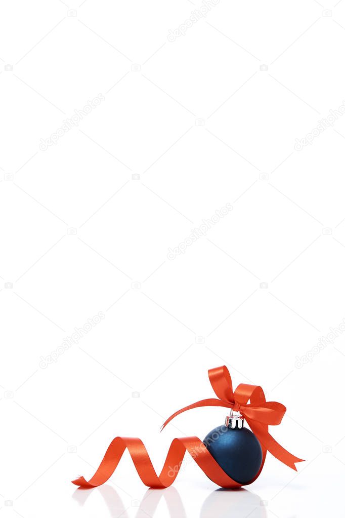 Blue christmas ball with red ribbon on a white