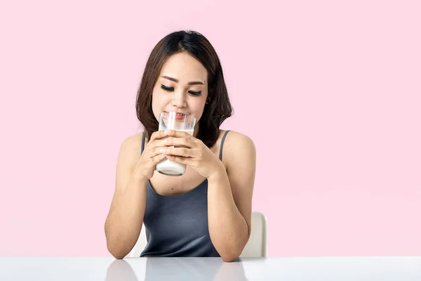 Ung kvinna som håller glas mjölk — Stockfoto