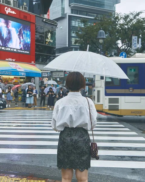 Frau mit Regenschirm läuft auf Straße — Stockfoto