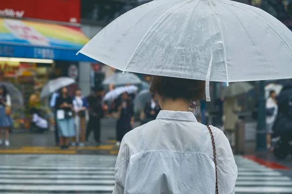 傘を持つ女性が道路を歩く — ストック写真
