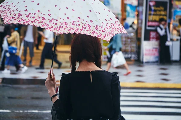 Frau mit Regenschirm läuft auf Straße — Stockfoto