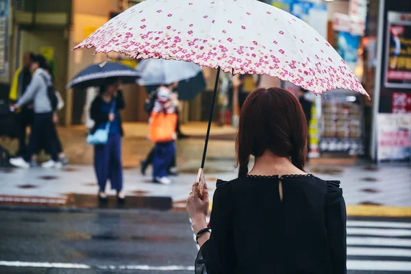 Mulher com guarda-chuva andando na estrada — Fotografia de Stock