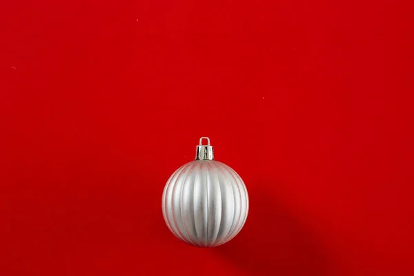Bola de Natal de prata no fundo vermelho flat lay — Fotografia de Stock