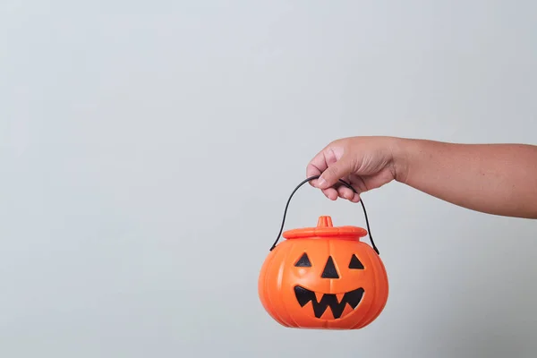 Hand holding halloween pumpkin bucket