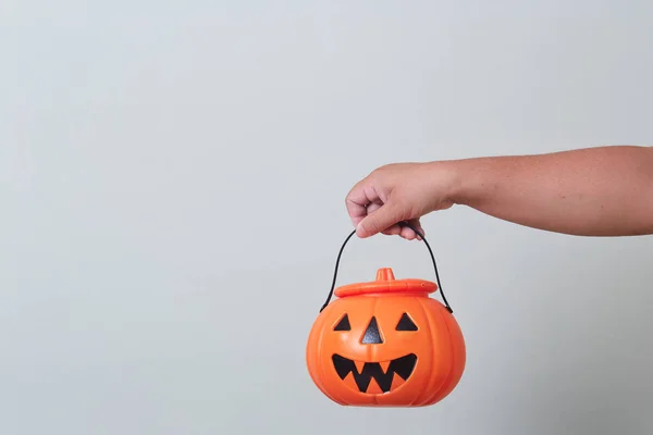 Hand holding halloween pumpkin bucket
