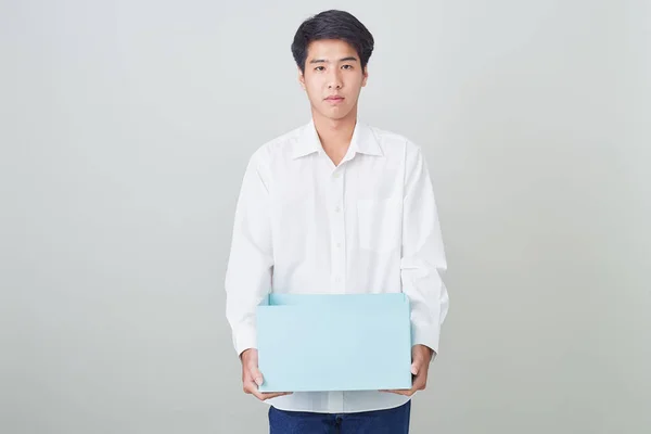 Giovane asiatico businessman holding un box — Foto Stock