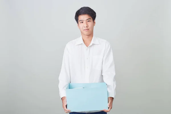 Молодой азиатский бизнесмен держит коробку — стоковое фото