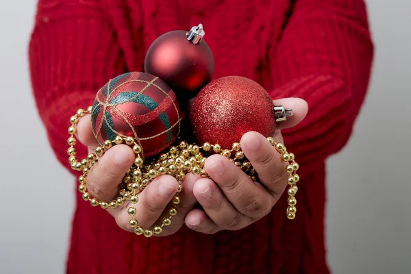 Mains féminines tenant une boule de Noël — Photo