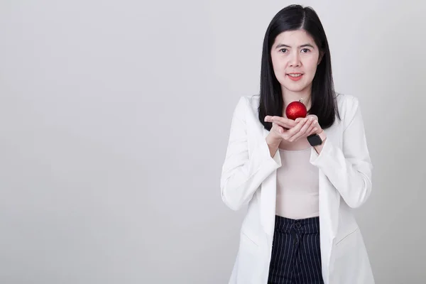 Mujer asiática mano sosteniendo una bola roja de Navidad — Foto de Stock