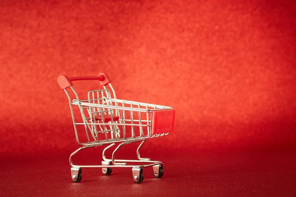 Vozík v supermarketu na rozostřeném červeném pozadí — Stock fotografie