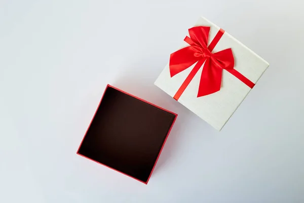 Біла подарункова коробка з червоною стрічкою на білому — стокове фото