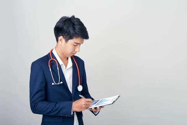 Asian male nutritionist with clipboard on light background — Stock Photo, Image