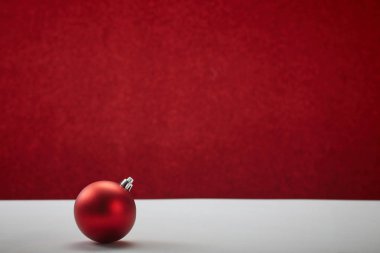 Beyaz masa kırmızı duvarda noel topu