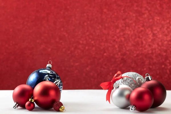 Boules de Noël sur table blanche mur rouge — Photo