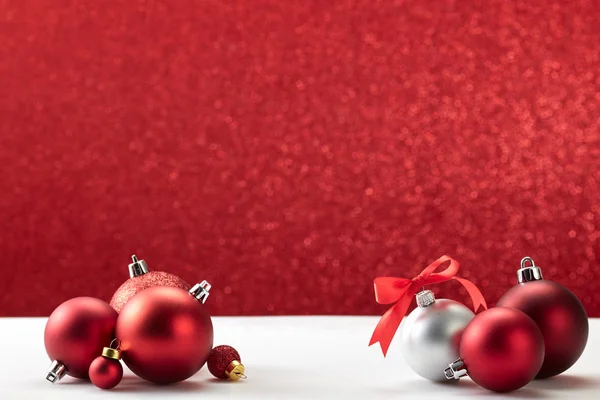 Boules de Noël sur table blanche mur rouge — Photo