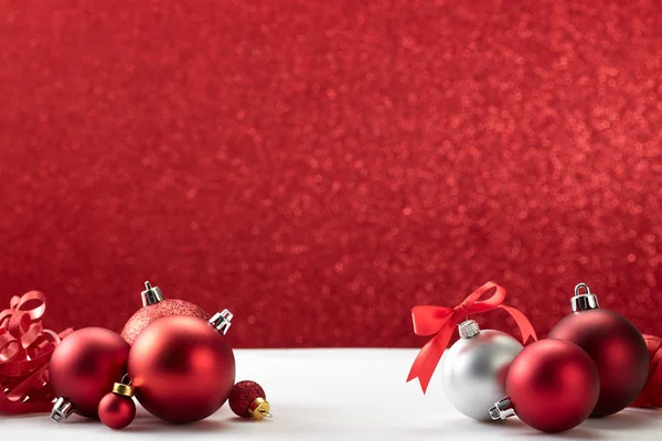 Boules de Noël sur table blanche mur rouge — Photo