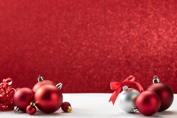 Boules de Noël sur table blanche mur rouge — Photo